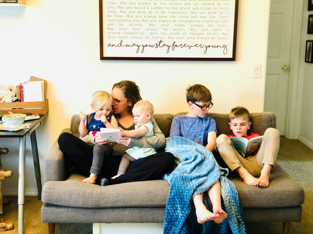 Mum sat on sofa with four children